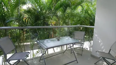 a table and chairs on a balcony with palm trees at Apartasuite Morros Vitri in Cartagena de Indias