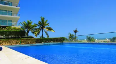 a large blue swimming pool next to a building at Apartasuite Morros Vitri in Cartagena de Indias