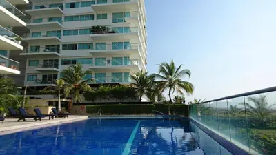 a swimming pool in front of a tall building at Apartasuite Morros Vitri in Cartagena de Indias