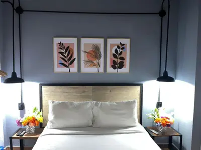 a bedroom with a bed with three pictures on the wall at Maloka Boutique Centro Histórico in Cartagena de Indias