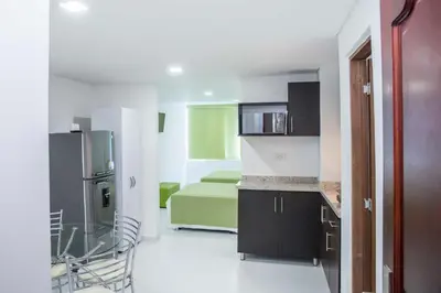 a kitchen with a refrigerator and a room with a bed at Apartamento 1904 El Laguito in Cartagena de Indias