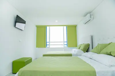 a hotel room with two beds and a window at Apartamento 1904 El Laguito in Cartagena de Indias
