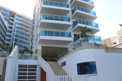 a white building with a staircase in front of it at Cartagena Beach Front in Cartagena de Indias