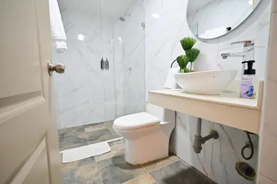 a bathroom with a shower and a toilet and a sink at Hotel SEREMA in Cartagena de Indias
