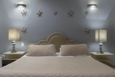 a bedroom with a large white bed with two lamps at Hotel SEREMA in Cartagena de Indias