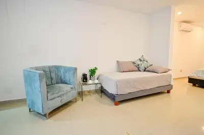 a bedroom with a bed and a chair at Hotel SEREMA in Cartagena de Indias