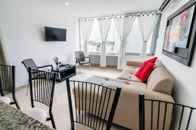 a living room with a couch and a table and chairs at Apartamento Unik Cartagena Edificio Faro Tequendama in Cartagena de Indias
