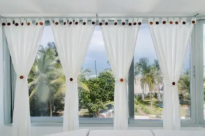 a room with a window with white curtains at Apartamento Unik Cartagena Edificio Faro Tequendama in Cartagena de Indias