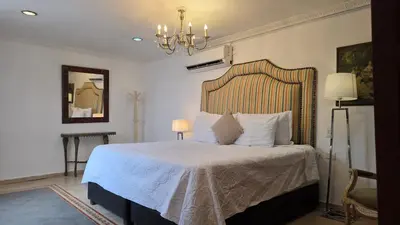 a bedroom with a bed and a chandelier at Hotel Casa la Tablada in Cartagena de Indias