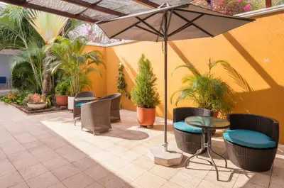 a patio with tables and chairs and an umbrella at Hotel Casa Cytia in Cartagena de Indias