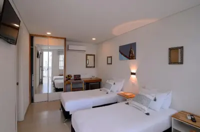 a hotel room with two beds and a mirror at Hotel Casa Cytia in Cartagena de Indias