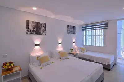 a bedroom with two beds with lights on them at Hotel Casa Cytia in Cartagena de Indias