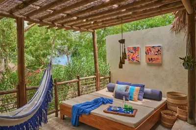 a porch with a bed and a hammock at Blue Apple Beach in Tierra Bomba
