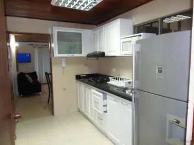 a kitchen with white cabinets and a refrigerator at Edificio Torre Centauro in Cartagena de Indias
