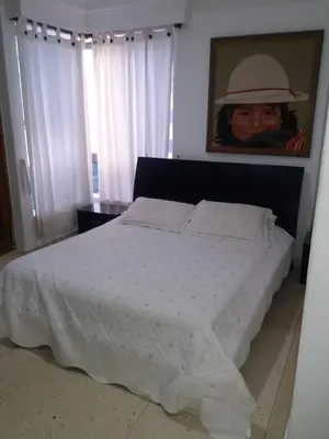a bedroom with a white bed with a hat on the wall at Edificio Torre Centauro in Cartagena de Indias