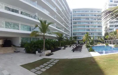 a large building with a swimming pool and palm trees at Apartamento Morros Epic Cartagena in Cartagena de Indias