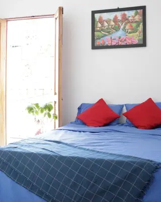 a bedroom with a blue bed with red pillows at Casa Edith in Cartagena de Indias
