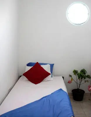 a bedroom with a bed with blue and red pillows at Casa Edith in Cartagena de Indias