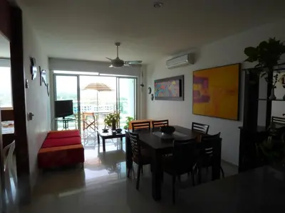 a dining room and living room with a table and chairs at Costa Azul Suites 802 in Santa Marta