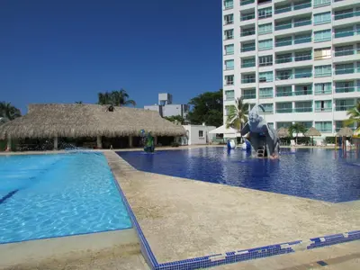 a large swimming pool with a large building at Costa Azul Suites 802 in Santa Marta