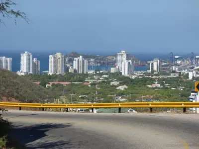 a yellow railing on a road with a city in the background at Costa Azul Suites 802 in Santa Marta