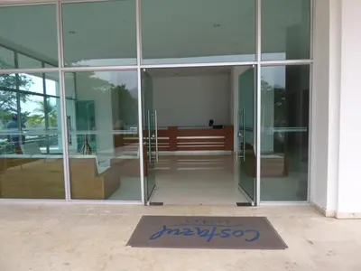 an entrance to a glass building with a welcome mat at Costa Azul Suites 802 in Santa Marta