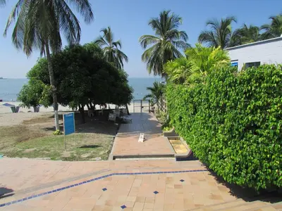 a walkway next to a beach with palm trees at Costa Azul Suites 802 in Santa Marta