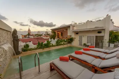 a villa with a swimming pool and a house at Hotel Casa Noi in Cartagena de Indias