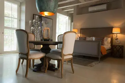 a dining room with a table and chairs and a bedroom at Hotel Casa Noi in Cartagena de Indias