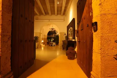 a hallway of a building with a table in the distance at Hotel Casa Noi in Cartagena de Indias