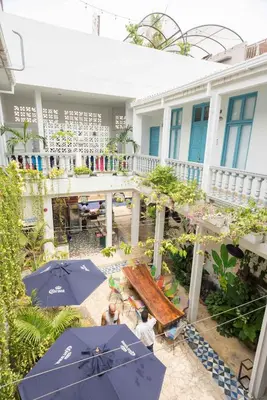 an outdoor patio with tables and umbrellas in front of a building at República Hostel Cartagena in Cartagena de Indias