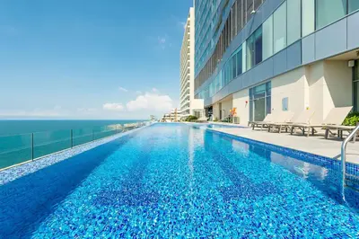 a swimming pool next to a building with the ocean at Hyatt Regency Cartagena in Cartagena de Indias