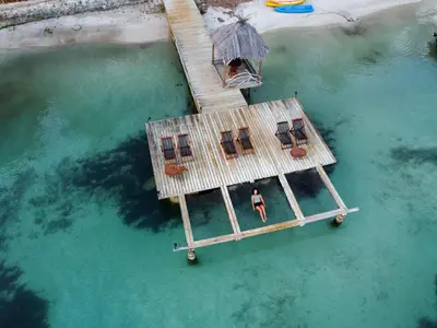 a man standing on a dock in the water at Isla Fuerte Eco House in Isla Fuerte