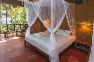 a bedroom with a bed with mosquito net at Isla Fuerte Eco House in Isla Fuerte