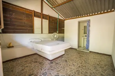 a bedroom with a white bed and a mirror at Eco Hotel Bosque Encantado in Isla Grande