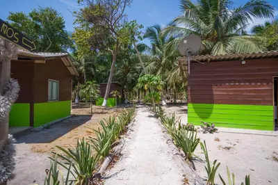 a path between two buildings with green and brown at Eco Hotel Bosque Encantado in Isla Grande