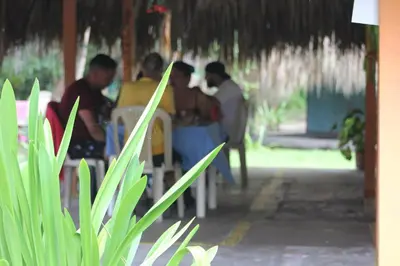 a group of people sitting at a table in a restaurant at Eco Hotel Las Palmeras in Isla Grande