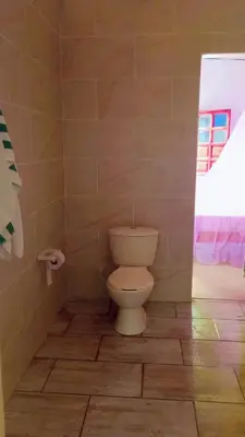 a bathroom with a toilet and a roll of toilet paper at ECOHOTEL LAS FLORES Econativo in Isla Grande