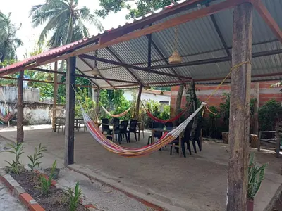 a hammock in a pavilion with tables and chairs at ECOHOTEL LAS FLORES Econativo in Isla Grande