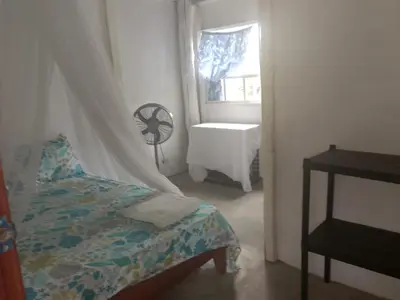 a bedroom with a bed and a window with a fan at ECOHOTEL LAS FLORES Econativo in Isla Grande
