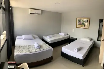 a room with three beds in a room at Hotel Prado 53 in Barranquilla