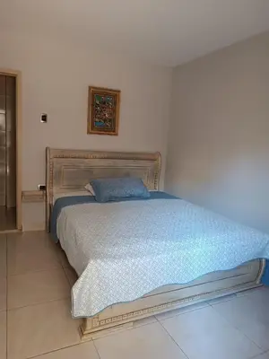 a bedroom with a bed with a blue bedspread at Hotel Prado 53 in Barranquilla