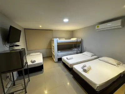 a room with two beds and a tv in it at Hotel Prado 53 in Barranquilla