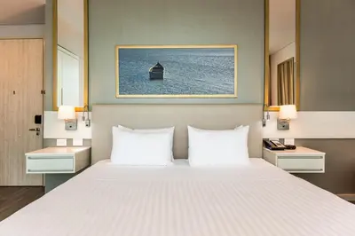 a bedroom with a large bed with white pillows at Crowne Plaza Barranquilla by IHG in Barranquilla