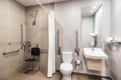 a bathroom with a toilet and a sink and a shower at Crowne Plaza Barranquilla by IHG in Barranquilla