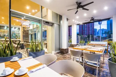 a restaurant with tables and chairs and a view of the city at Crowne Plaza Barranquilla by IHG in Barranquilla