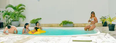 a group of women in a swimming pool with a surfboard at Hotel Isla Capri in Cartagena de Indias