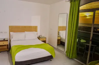a bedroom with a bed and a view of the ocean at Hotel Isla Capri in Cartagena de Indias