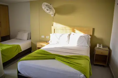 a hotel room with two beds and a fan at Hotel Isla Capri in Cartagena de Indias