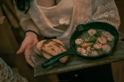 a woman holding a pan of food with bread at Casa Be Getsemaní in Cartagena de Indias